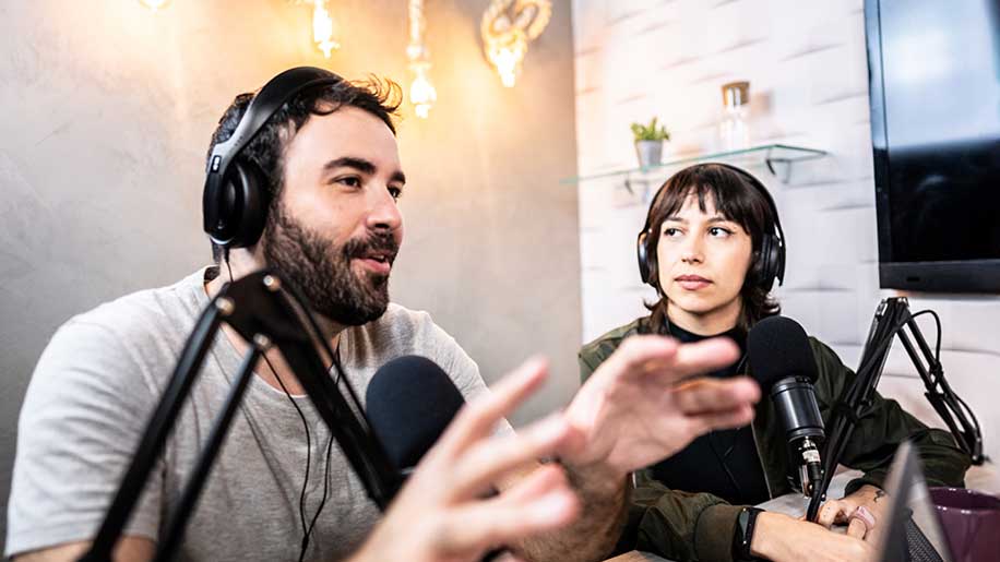 Zwei Personen im Studio am Podcast aufnehmen.