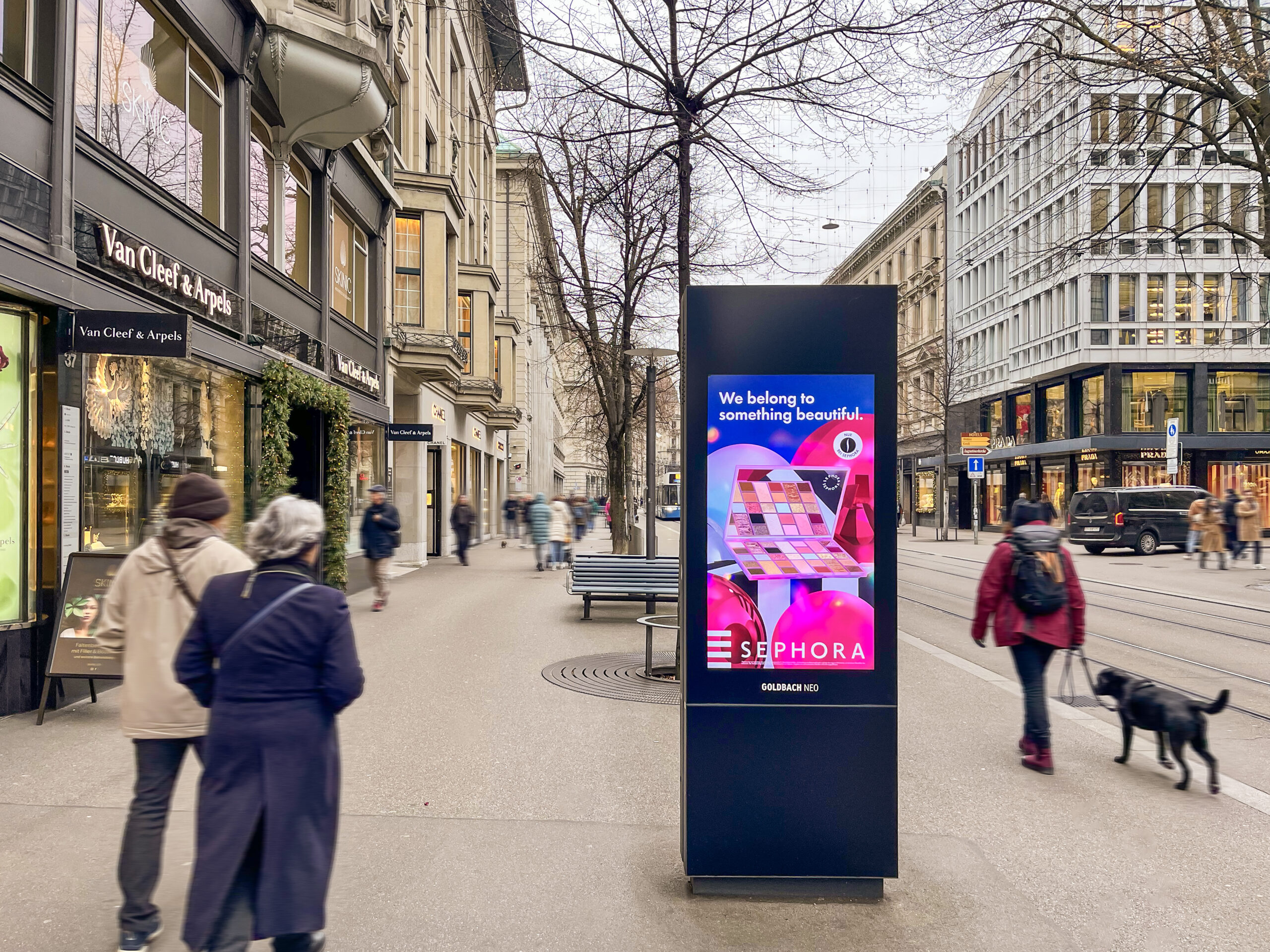 DOOH Plakatstelle in der Bahnhofstrasse Zürich und Fussgänger, die vorbeispazieren.