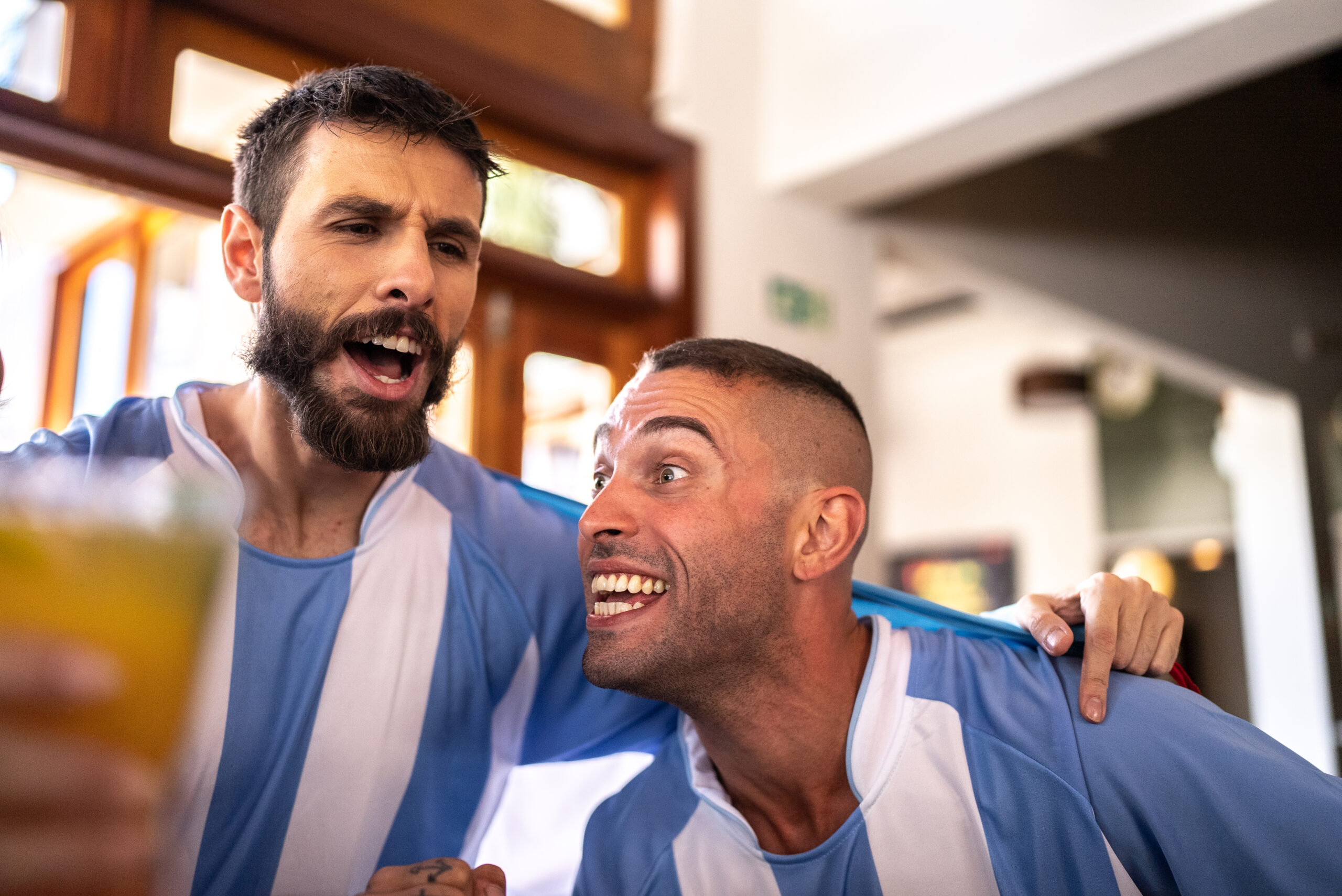 Friends celebrating Argentinian team winning in a bar
